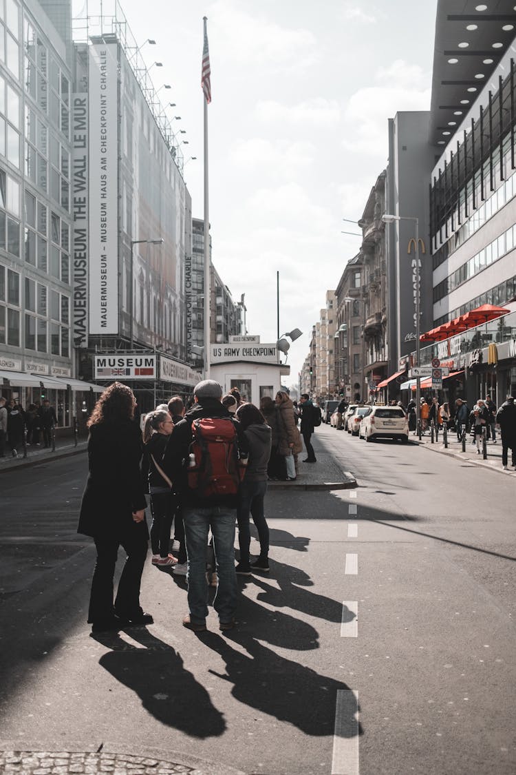 People Standing In Cue On Street In City