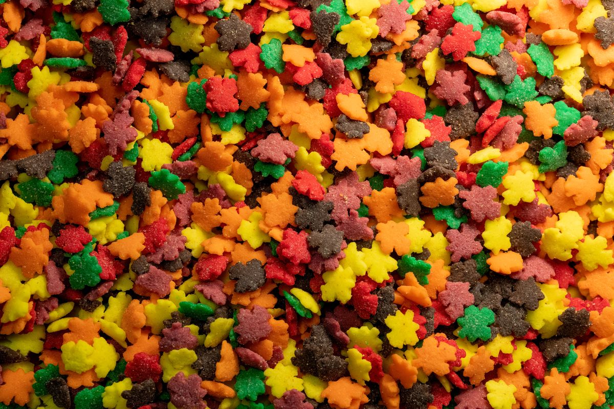 Close-up of colorful leaf-shaped candy sprinkles ideal for autumn-themed desserts.