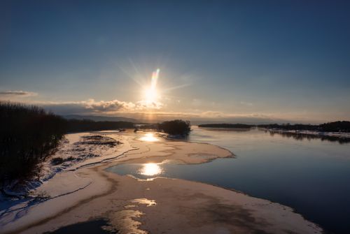 Free Scenic winter sunset over a river with icy banks and vibrant sky near Wabasha, Minnesota. Stock Photo