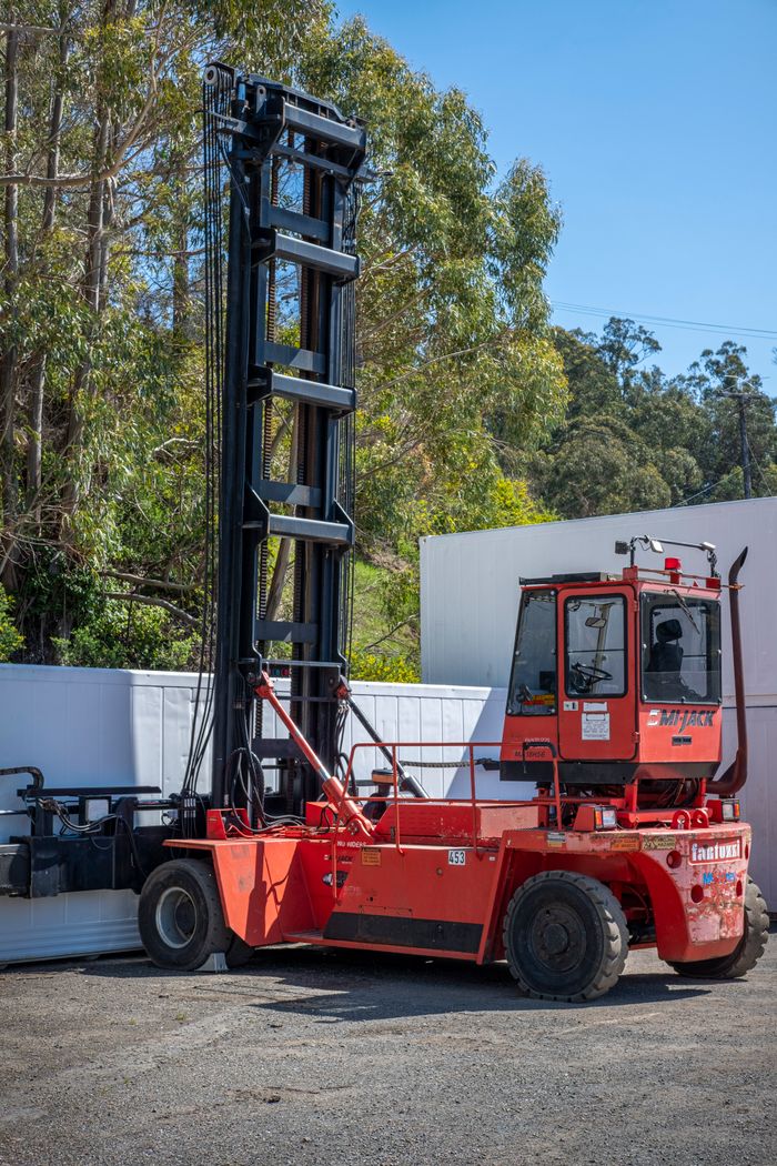 Forklift loading goods beside a warehouse