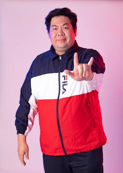 Portrait of an adult man in Fila sportswear gesturing in a studio setting.