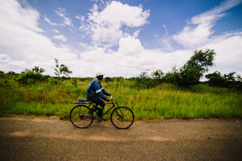 afrikalı adam, binmek, bisiklet sürmek içeren Ücretsiz stok fotoğraf