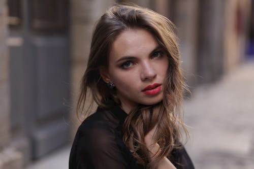 Photographie De Mise Au Point Sélective De Femme En Haut Noir Avec La Main Gauche Sur Les Cheveux