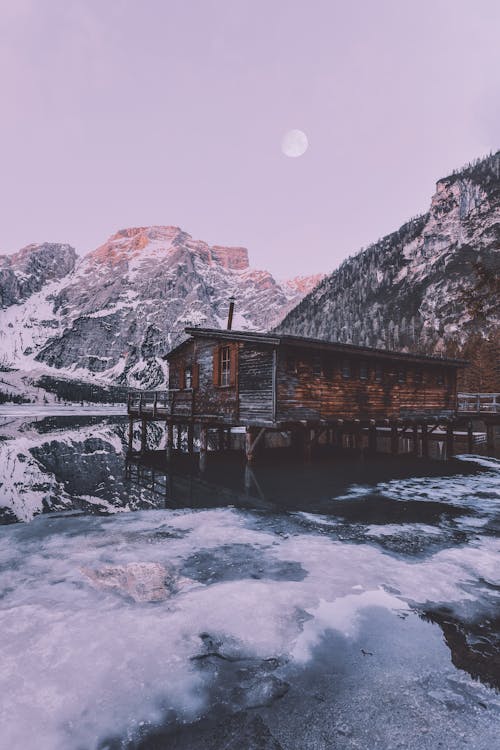 Maison En Bois Brun Près De La Montagne Couverte De Neige