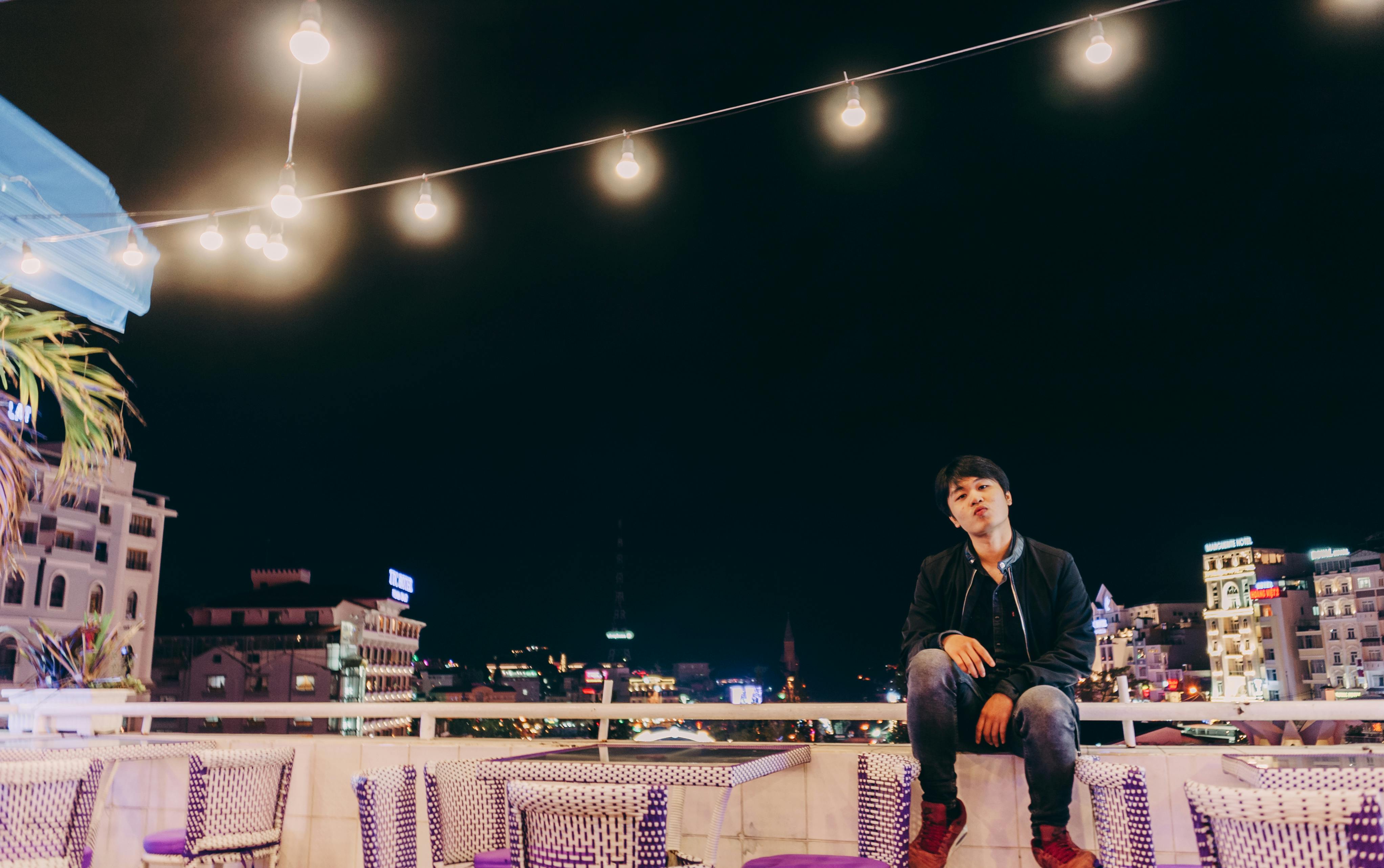 城市夜景中，一名男子站在屋顶上