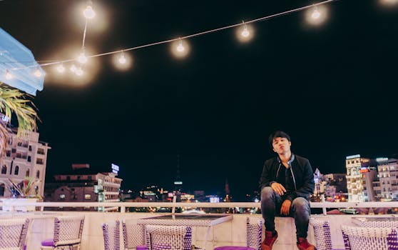 城市夜景中，一名男子站在屋顶上