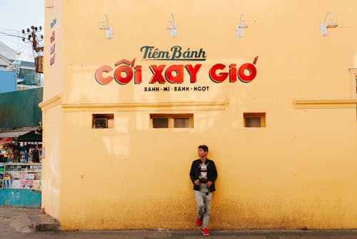 Man Leaning On Yellow Painted Wall