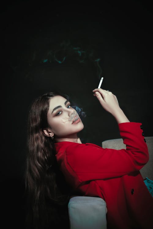 Woman in Red Coat Smoking Cigarette