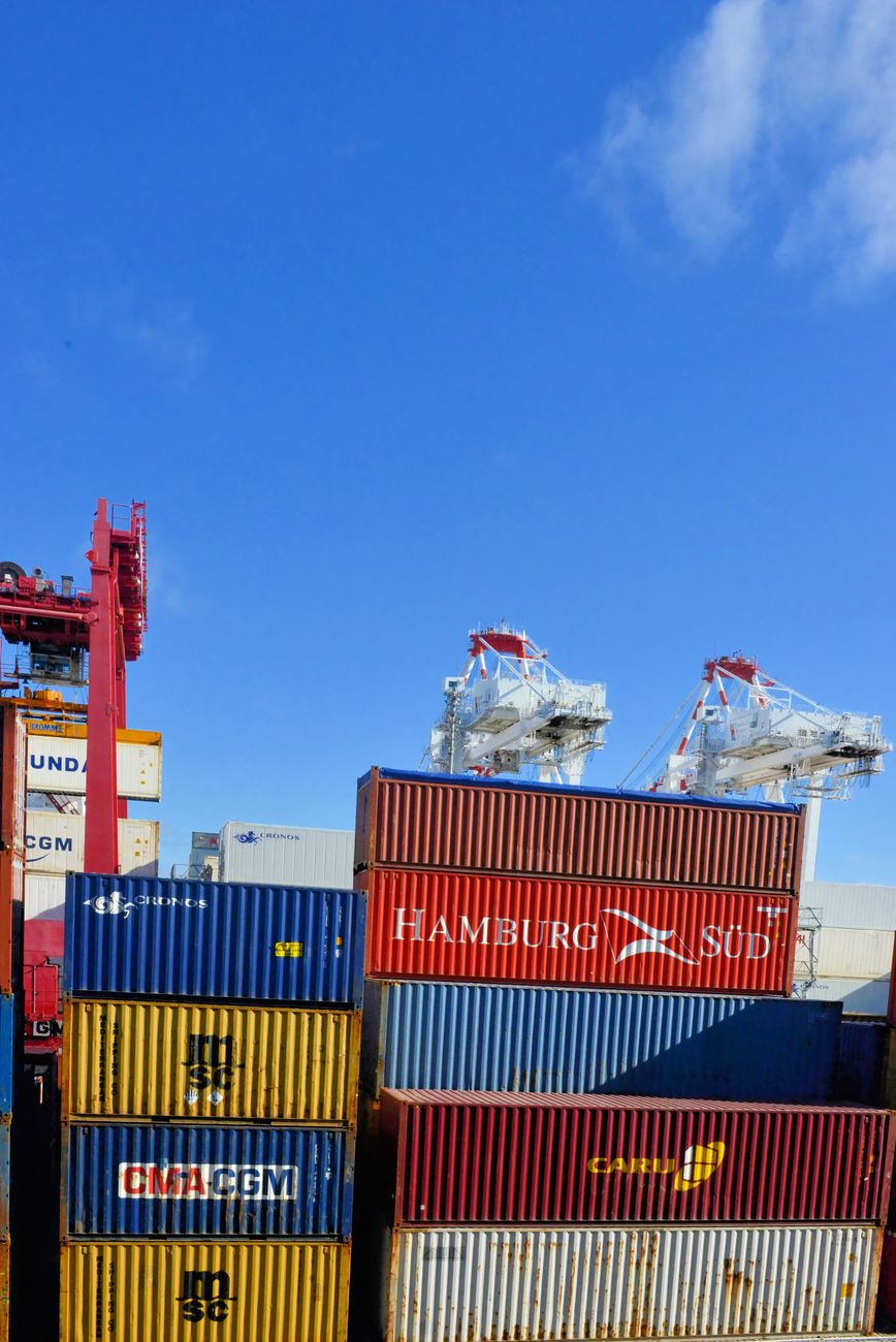 Stacks of containers at a cargo terminal show where shipment data and customs filings decide who gets tariff refunds first