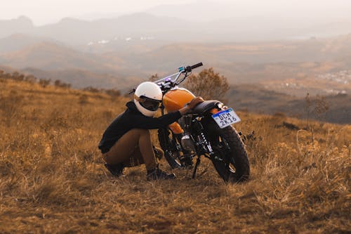 Motorcyclist Checking the Engine After Driving up the Hill