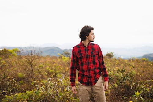 Man in a Flannel Shirt on Top of a Mountain