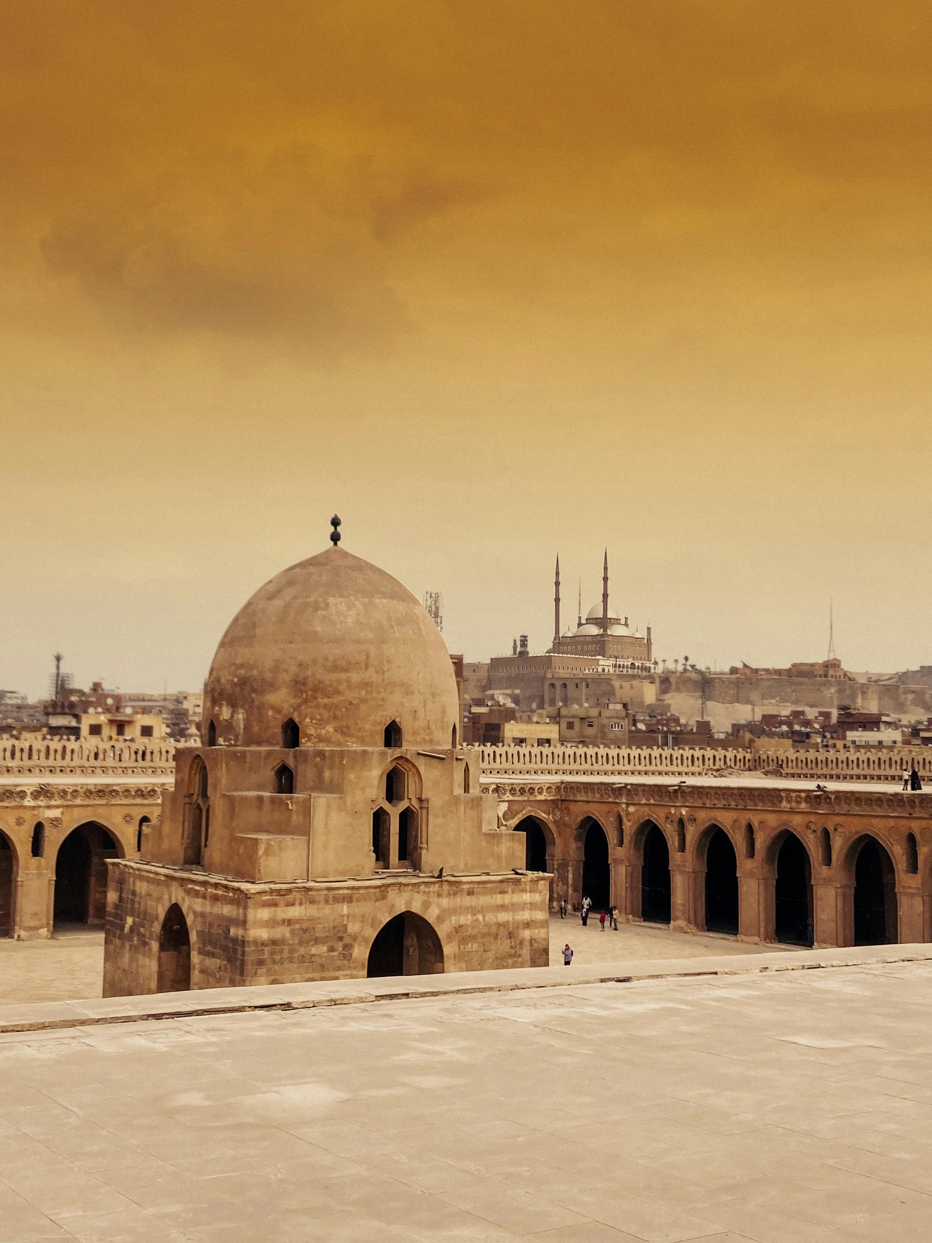 Scenic view of Ibn Tulun Mosque in Cairo with a vibrant sky at sunset.