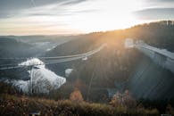 薄雾笼罩着森林，环绕着美丽的桥梁和水坝，与日出景色相映成趣