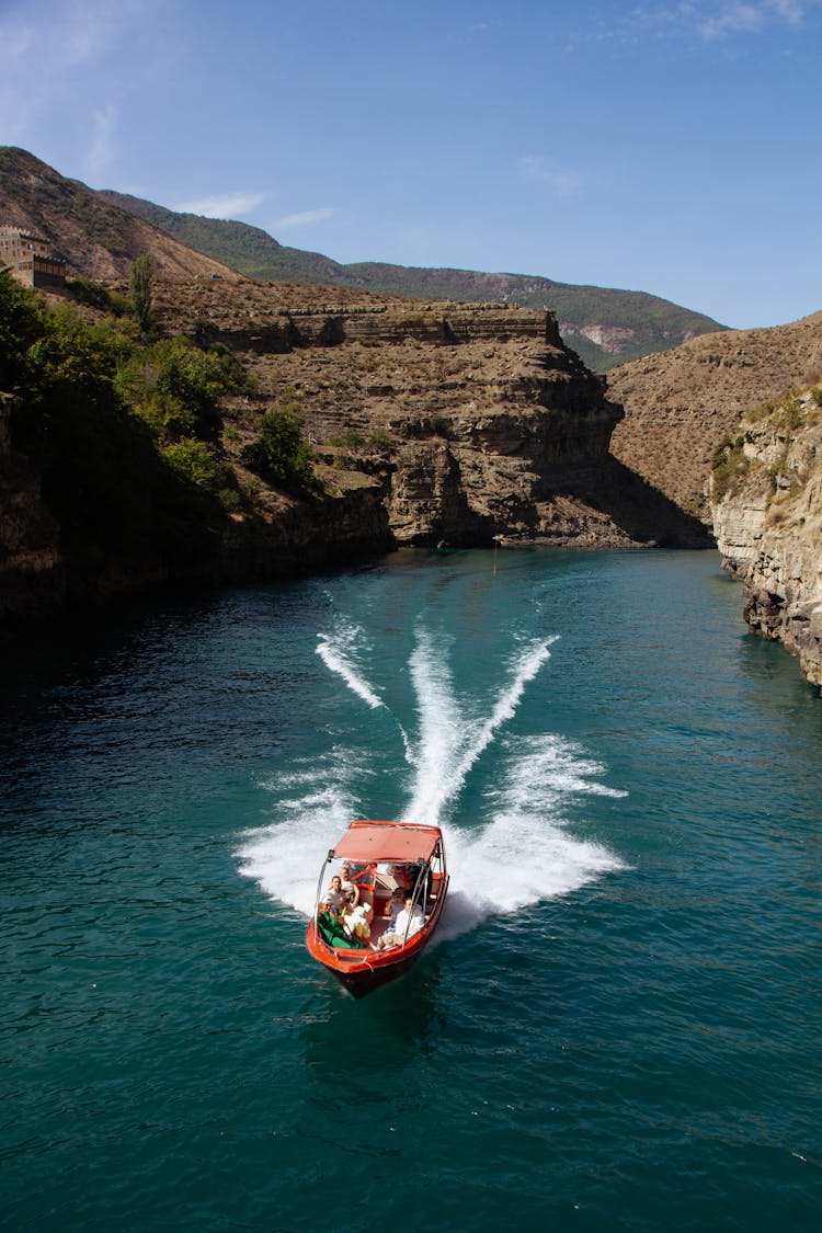 Rocky Landscape And A Red Boat On A Turquoise Water