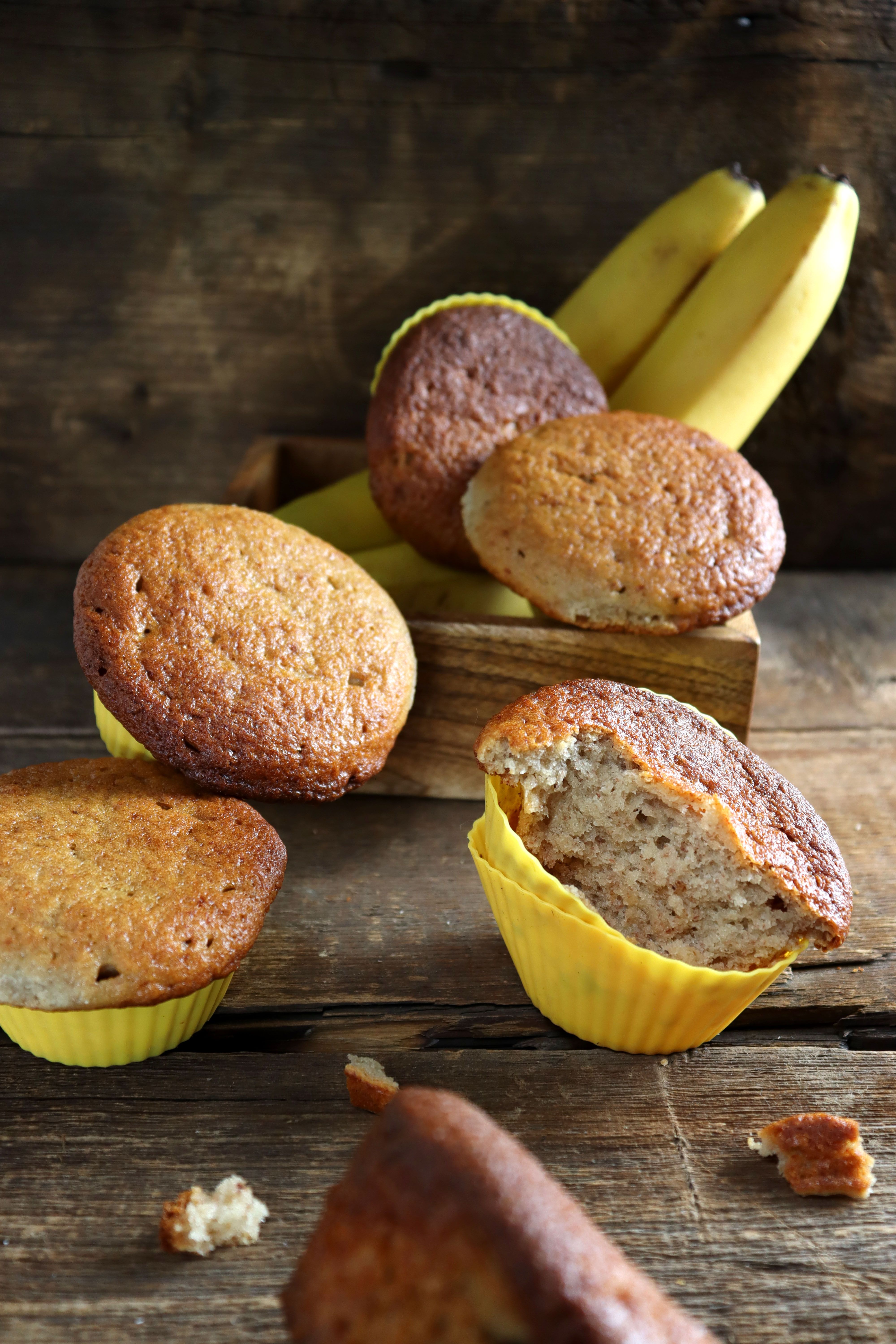 Homemade banana muffins with fresh bananas on a wooden table