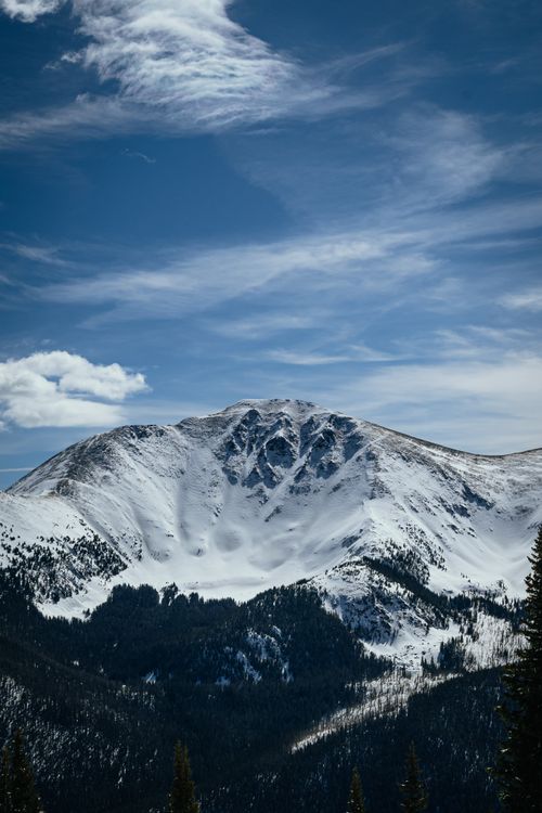 Free A stunning snow-capped mountain range under a clear blue sky, perfect for winter scenery lovers. Stock Photo