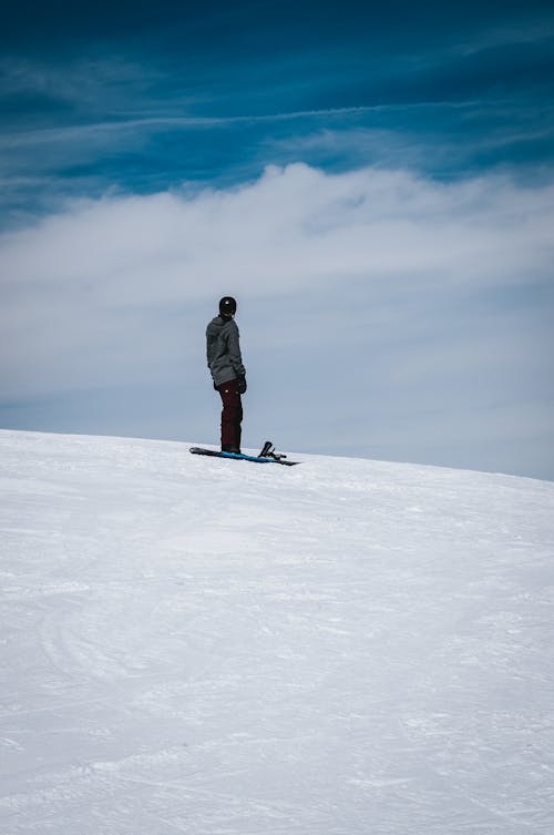 Person Standing on Snowboard on Sunlit Snow