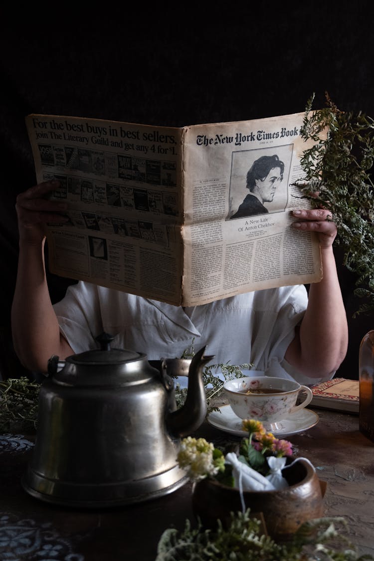 Person Holding And Reading Newspaper