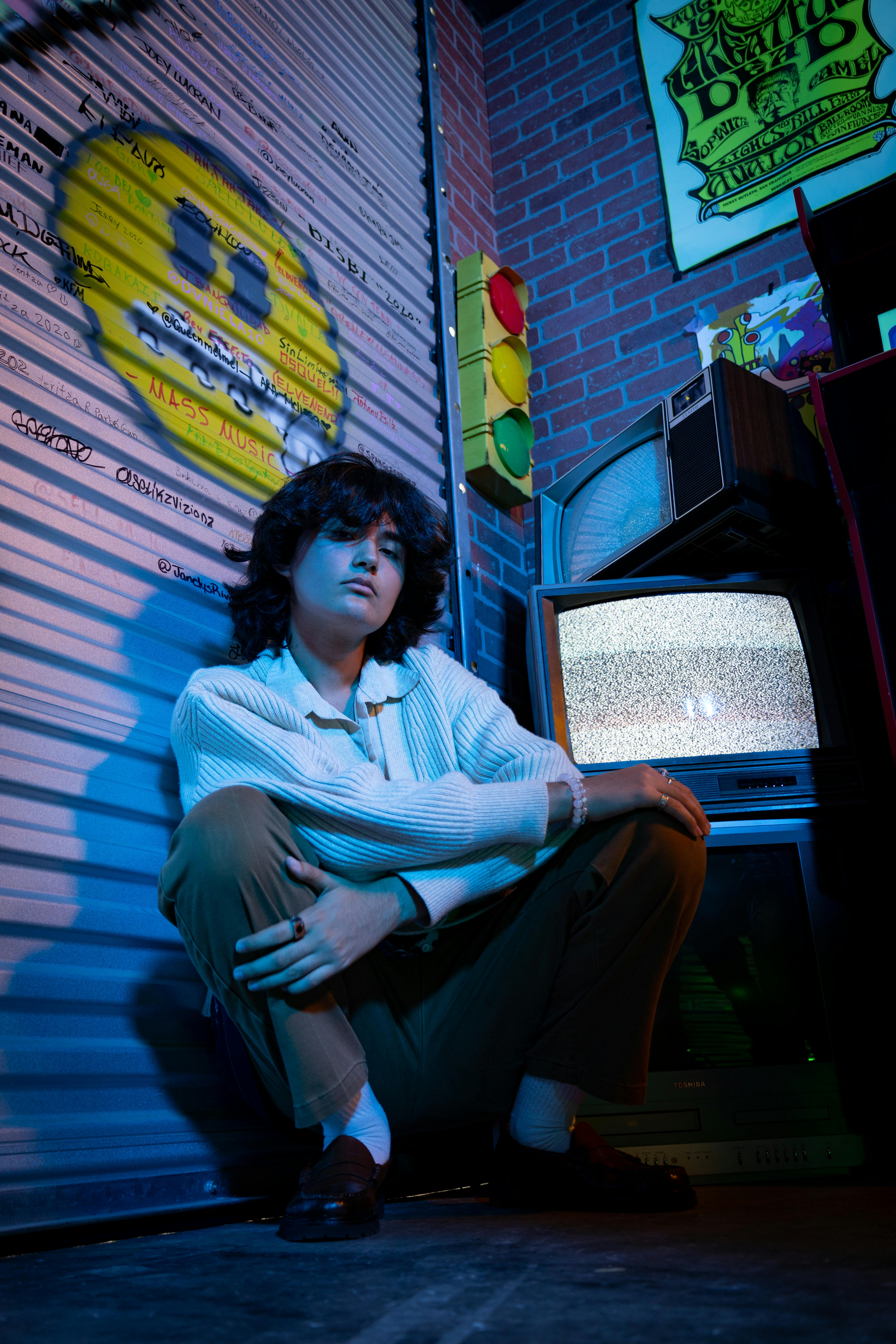 a man sitting on the ground in front of a television