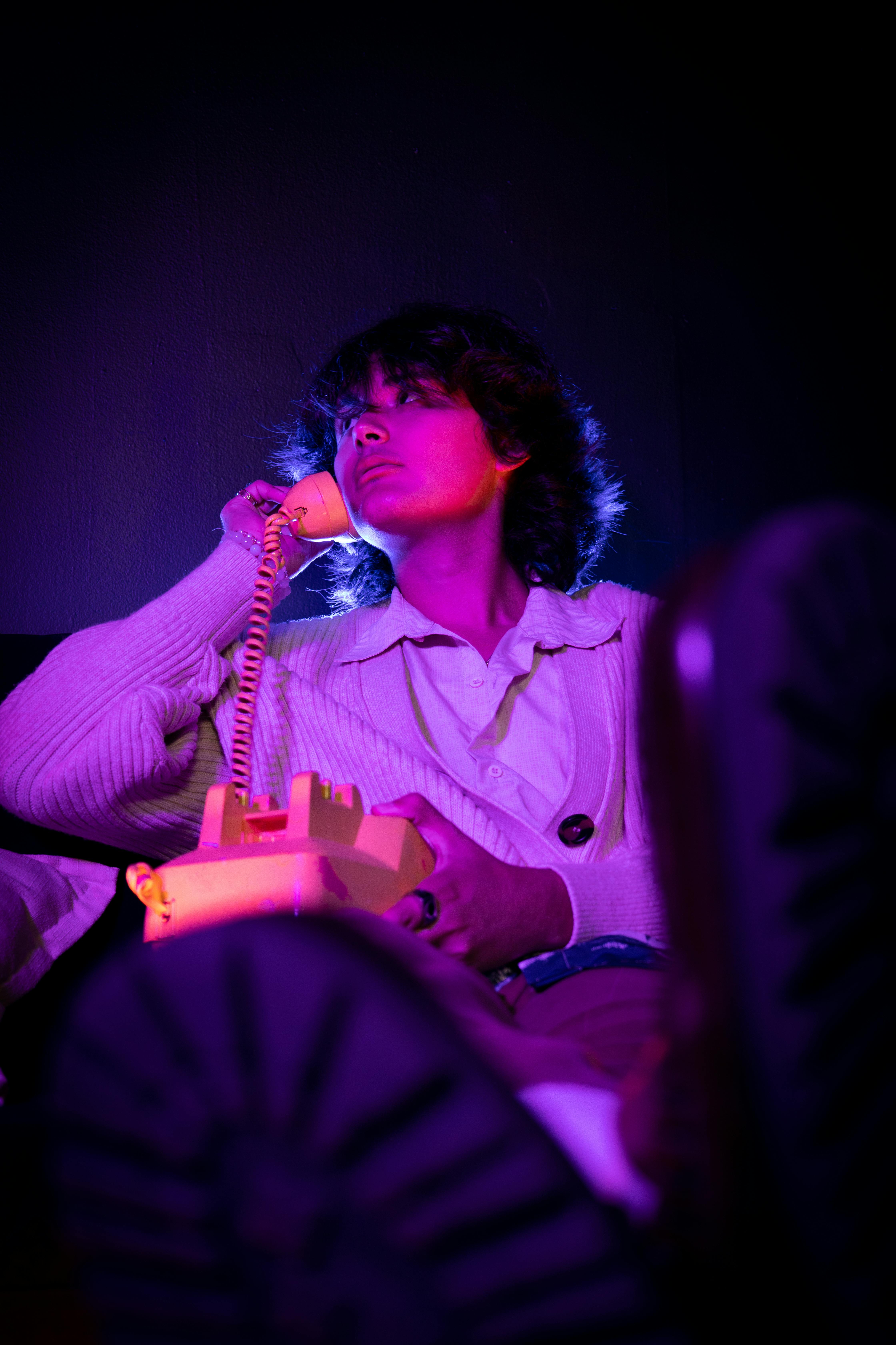 a woman sitting on a phone in a dark room