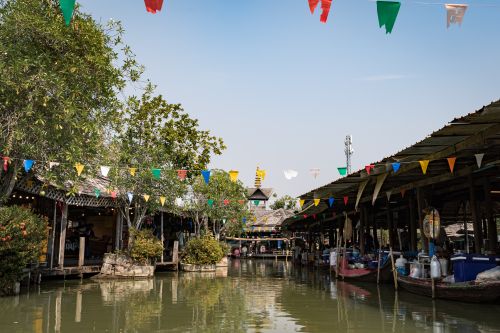 Free Colorful flags adorn a bustling floating market on a sunny day. Stock Photo