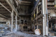 探索一座废弃工厂的内部，那里有裸露的混凝土和生锈的金属，显得十分怪异