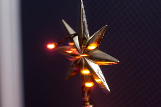 黑暗背景下，金色星星的特写镜头映衬着温暖的圣诞灯光