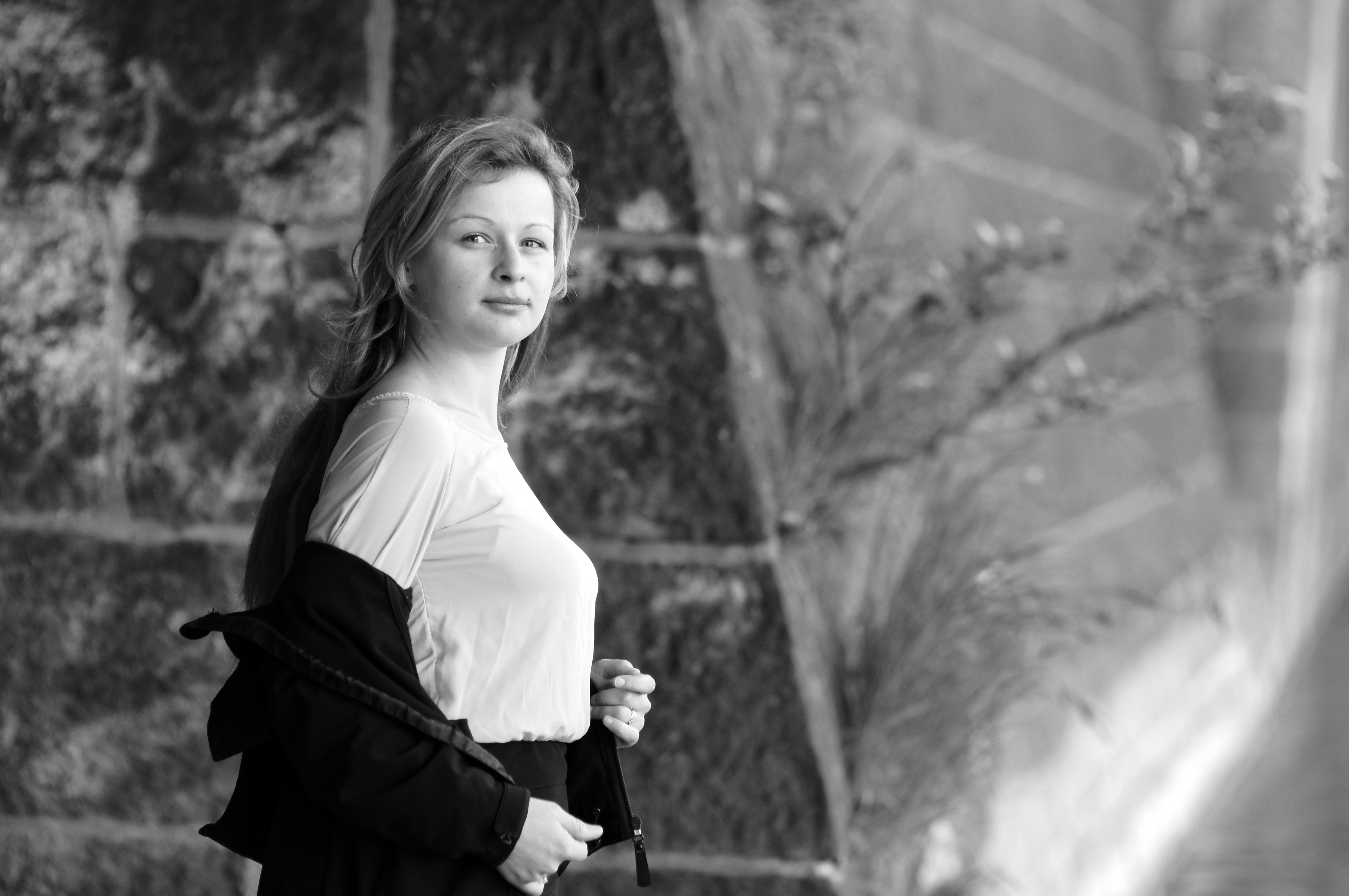 A woman is standing in front of a wall · Free Stock Photo