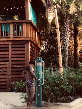 A man taking an outdoor shower at a tropical resort in Orlando, Florida.