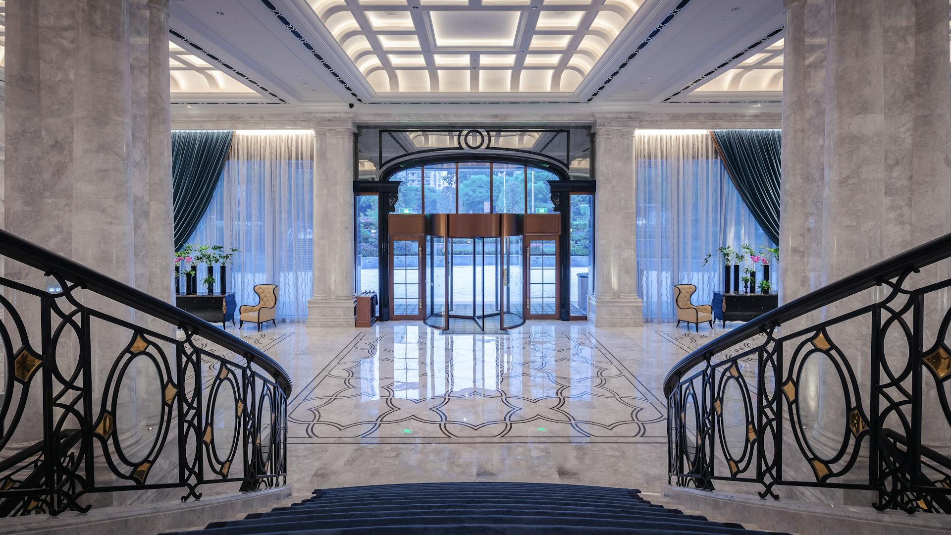 Elegant hotel lobby with a majestic staircase and ornate interior design.