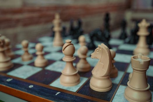 Detailed close-up of chess pieces on a checkered board, indoor setting.