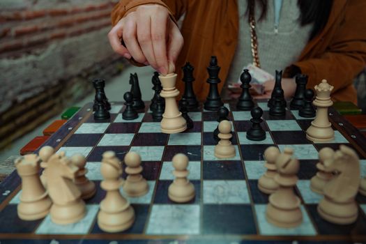 A person playing chess, highlighting strategic decision-making with a focus on hand movements.
