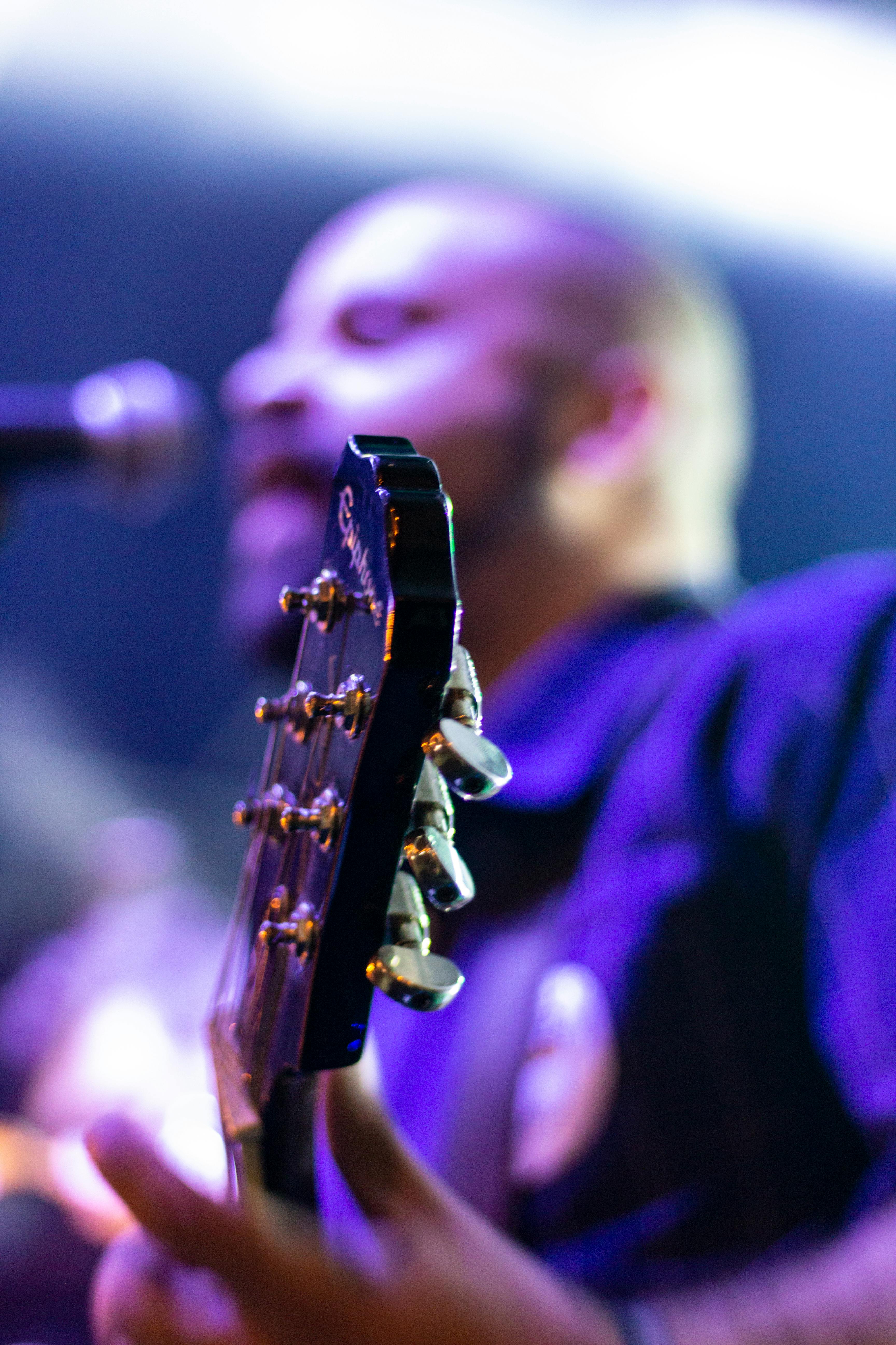 photo of man plying guitar