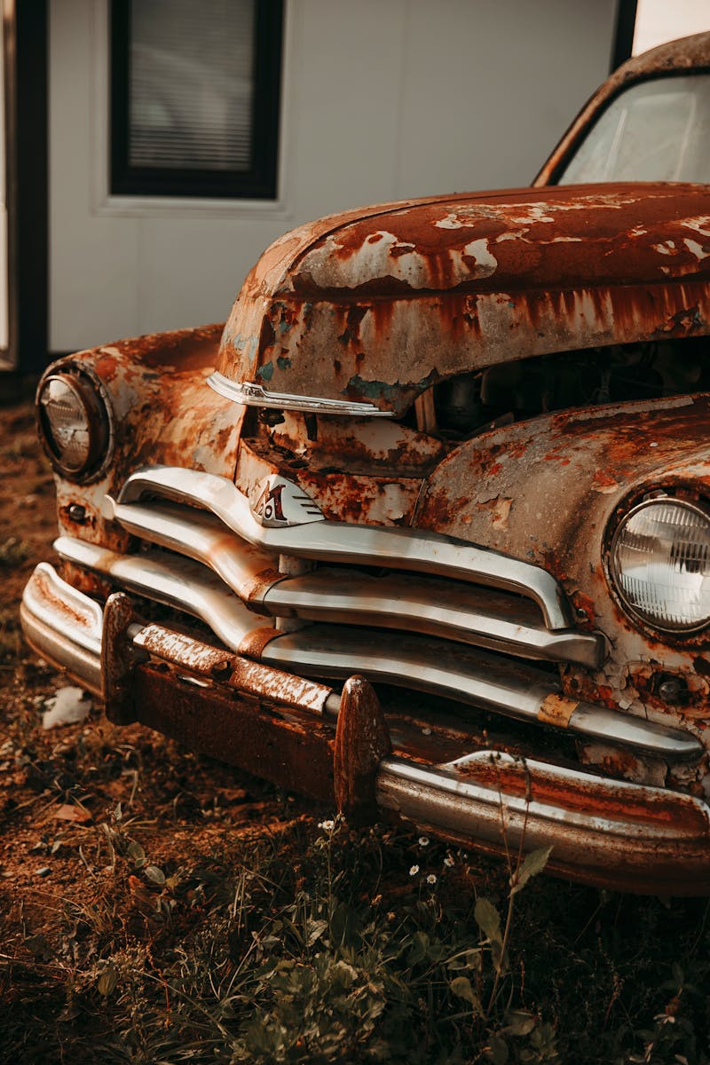 Old rusty car sitting in a yard, representing a junk vehicle that could be sold for cash