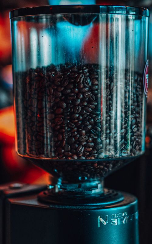Free Close-up of coffee beans in a transparent grinder, capturing the rich aroma in a Baku cafe. Stock Photo