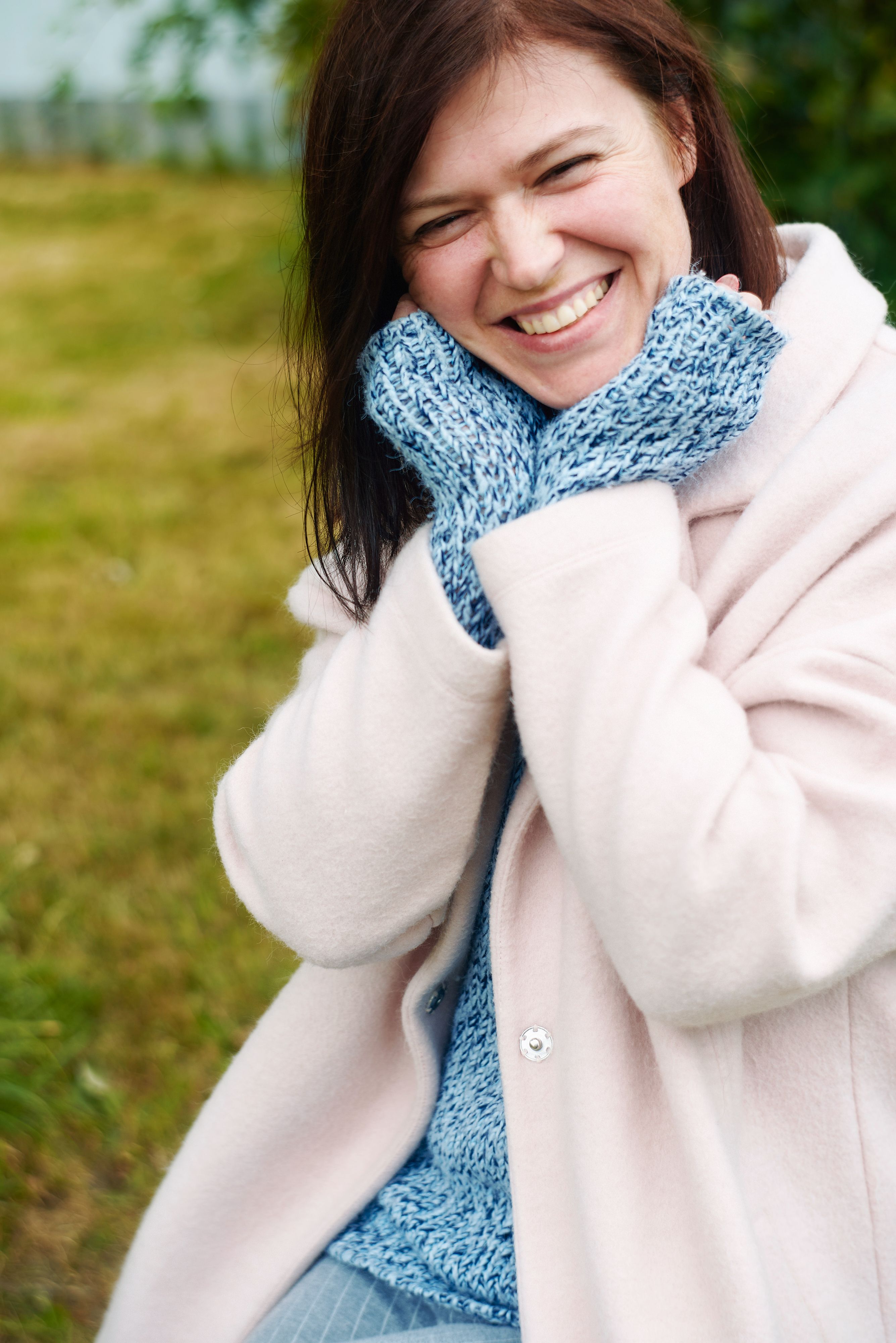 Happy woman enjoying winter outdoors in a warm coat and mittens.