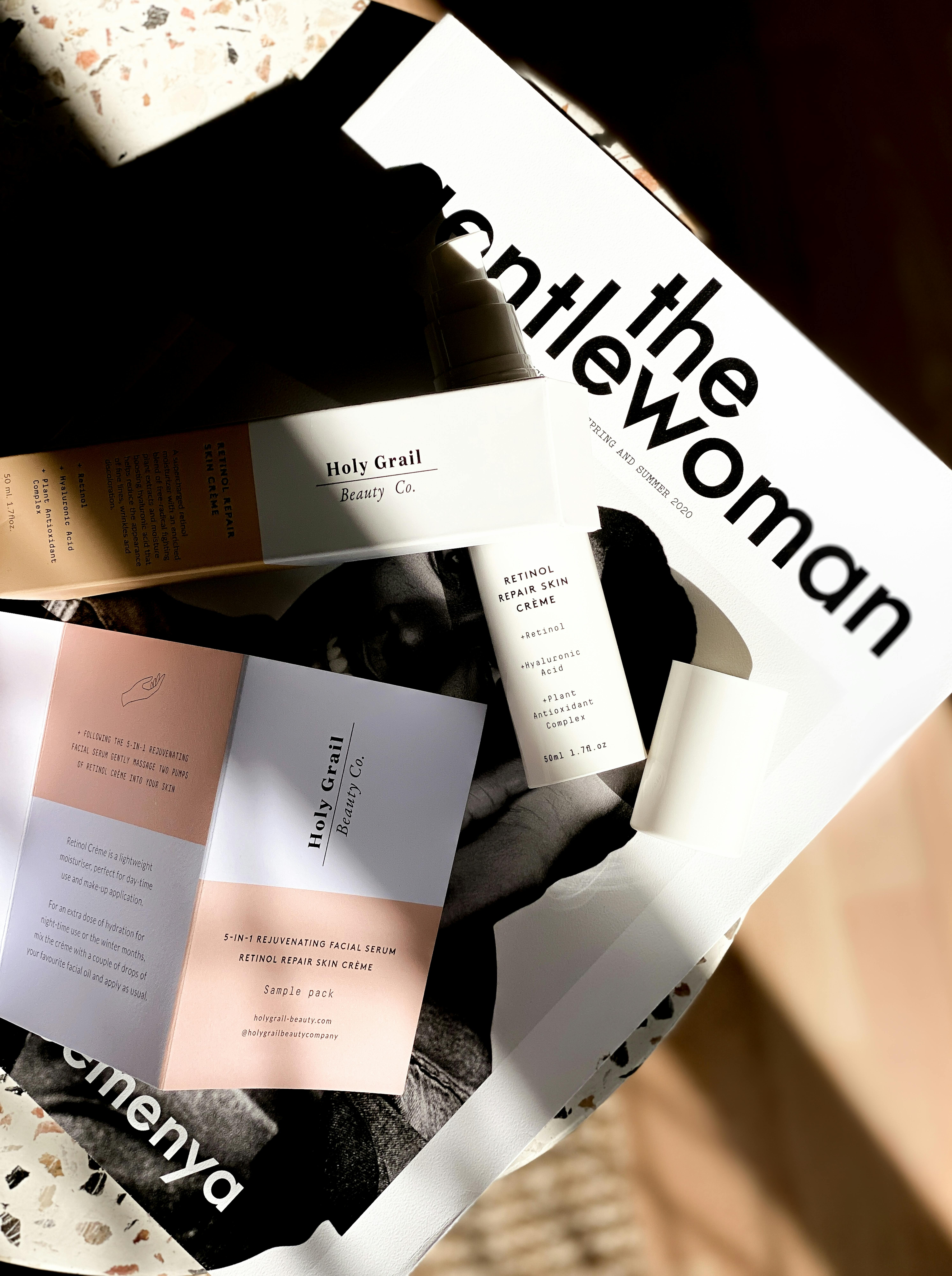 Top view of a magazine layout with beauty product advertisements in a bright and artistic setting.