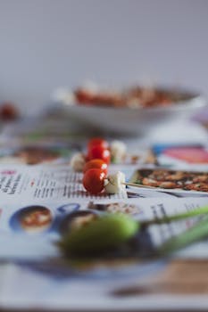 Artistic close-up shot of cherry tomatoes and cauliflower skewered and placed on newspapers.