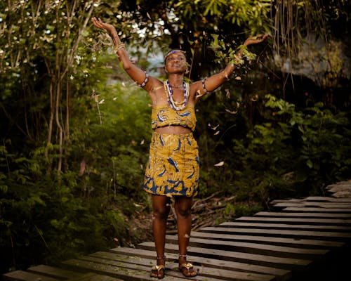 A Woman in Traditional Africal Clothing with Hands Raised