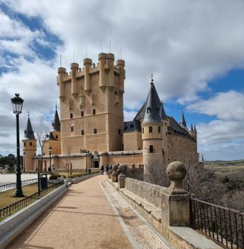 A captivating image of the historic Alcázar of Segovia under a blue sky, showcasing its gothic architecture.