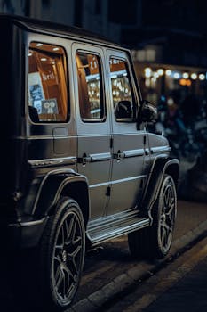 Stylish Mercedes-Benz G-Class parked under city lights, showcasing modern luxury design.