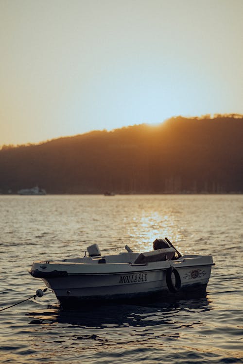 Empty Motorboat near City at Sunset