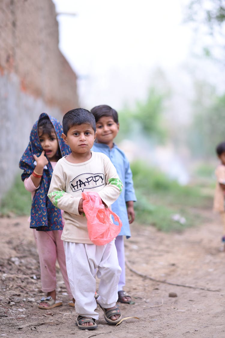 A Group Of Little Children Standing Outdoors