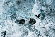 特写镜头展示嵌入岩石的冰，呈现冬季霜冻的纹理