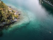 无人机拍摄下，一座郁郁葱葱的绿色岛屿被清澈的绿松石水环绕