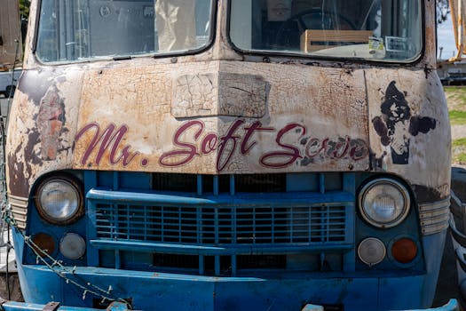 A close-up of a weathered vintage ice cream truck featuring the text 'Mr. Soft Serve'.
