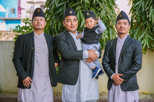 Free A group of men and a child wearing traditional clothing, posing outdoors. Stock Photo