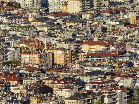 A dense urban landscape in Alanya, Turkey, showcasing residential buildings with orange rooftops.