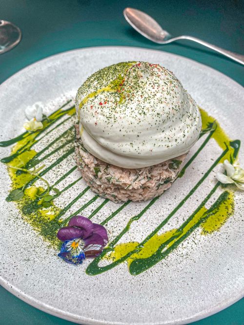 Free Elegant dessert with whipped cream and edible flowers on a plate. Stock Photo