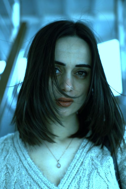Free A dramatic portrait of a woman with long brown hair evoking emotion. Stock Photo